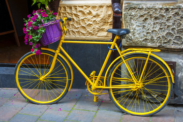 Yellow bicycle with flower basket
