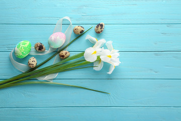 Easter eggs with spring flowers on color wooden table