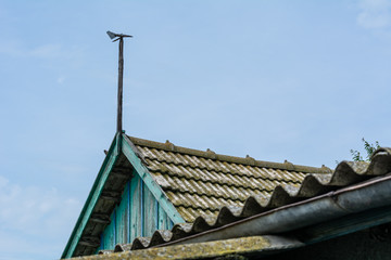 Fototapeta premium Weathervane on the roof of the old house