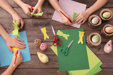 Little children making Easter decorations at table