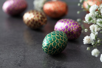 Chocolate Easter eggs in colorful foil wrap on grey background