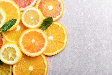 Many citrus slices on gray background, top view
