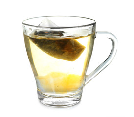 Brewing of hot beverage in glass cup using teabag, on white background
