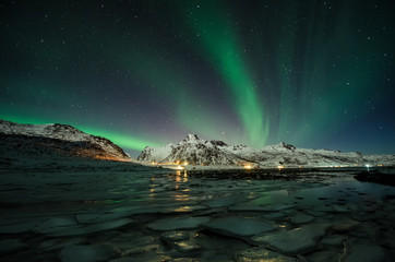 Fototapeta na wymiar LOFOTEN ISLANDS, NORWAY - FEB 2018 - Man under Aurora Borealis