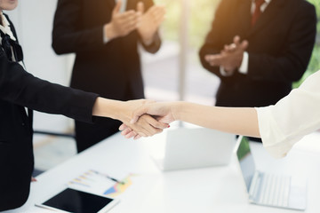 Business people shaking hands, finishing up a meeting to seal a deal with his partner business with colleague clap hands to congrats.