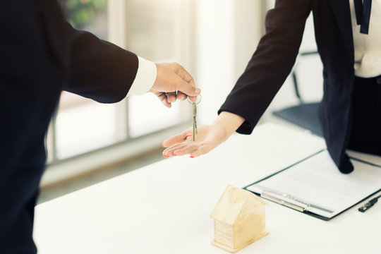 Real estate agent giving keys to apartment owner, buying selling property business. Close up of woman hand taking house key from realtor. Mortgage for purchasing flat, getting access to own home