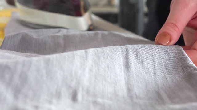 A woman irons a pair of pants - closeup