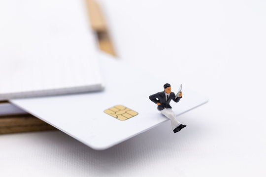 Miniature people : Shopper reading catalog book on credit card, payment. Image use for Business and shopping concept.