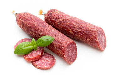 Salami smoked sausage, basil leaves and peppercorns isolated on white background.