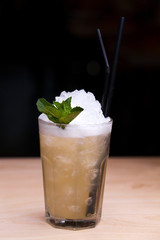 Cool lemonade in glass on wooden table in Summer