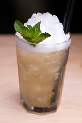 Cool lemonade in glass on wooden table in Summer