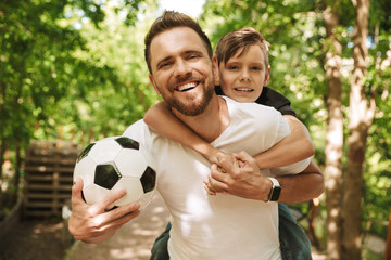 Happy young father have fun with his little son with football