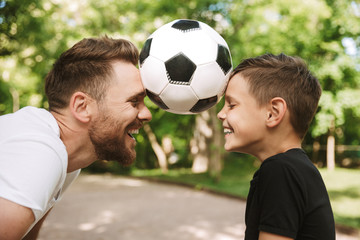 Happy young father have fun with his little son with football