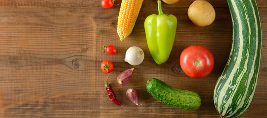 set of vegetables laid out on a wooden table. Top view. Free space for text.