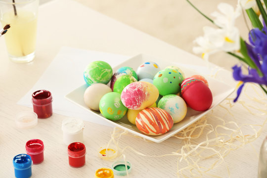 Plate with colorful painted Easter eggs on table