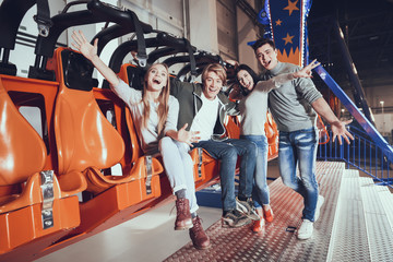 Group of four friends laughing in amusement park