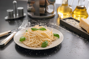 Plate with spaghetti and basil on table. Delicious pasta recipes