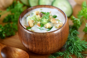 Cold soup Tarator with kefir in a wooden bowl