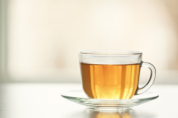 Glass cup of tasty green tea on table