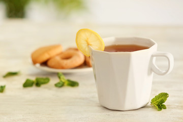 Cup of tasty tea with lemon slice on table