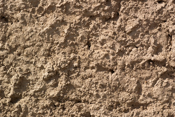 Close-up photograph of the beige cement rough wall with deep texture 