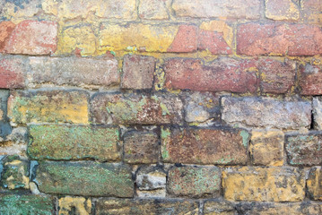 Fototapeta premium Photo of an old dilapidated multi-colored stone wall