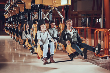 Happy young people ride on attractions.