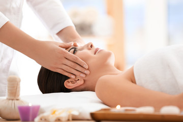 Obraz na płótnie Canvas Young woman enjoying facial massage in spa salon