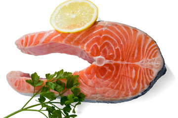 Salmon steak with a sprig of parsley and lemon slice isolated on a white background..