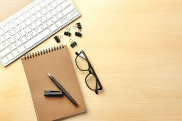 Computer keyboard and stationery on light background, flat lay. Workplace table composition