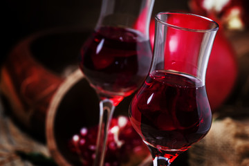 Homemade pomegranate liqueur, still life in rustic style, old wooden background, selective focus