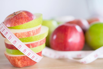 fresh green and red apple slice with measuring tape, healthy fruit for weight control and dieting