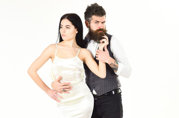 Bearded hipster with bride dressed up for wedding ceremony, copy space. Wedding concept. Woman in wedding dress and man in vest. Couple in love, bride and groom in elegant clothes, white background.
