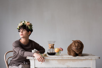 woman sitting at table with her cat drinking coffee