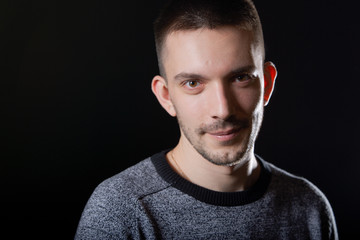 Obraz premium Portrait of a handsome young man. Black background.