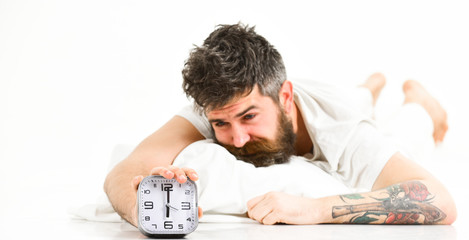 Hipster with beard and mustache awake because of alarm clock.