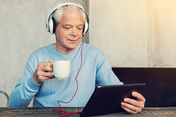 Interesting film. Modern active pensioner drinking tea while watching film on his new device