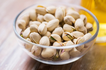 food concept - close up of pistachio nuts in glass bowl