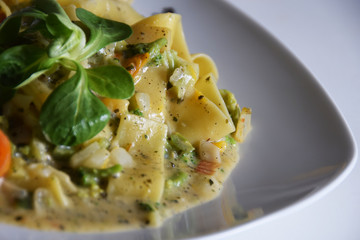 tagliatelle pasta with vegetables, cream-herb sauce, tomatoes