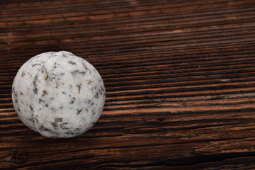 herbal white bath ball with foam in a bathtub on a brown background