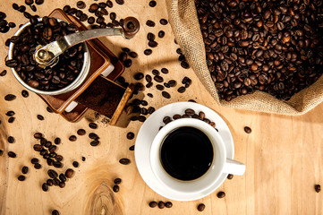 Sacco di caffè in grani con macinacaffe e tazza