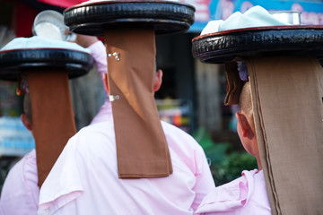 des nones bouddhiste qui portent un plateau sur la t&ecirc;te 