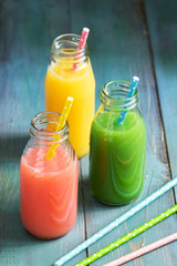 Pink, yellow and green drink bottled. Colorful juices. Summer drinks.