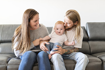 parent with baby daughter on sofa at home