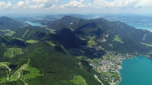 Aerial panoramic view of lake Wolfgangsee in summer, scenery with majestic lush green slopes and peaks of Alps mountains, alpine town St Gilgen - picturesque landscape of Austria from above, Europe
