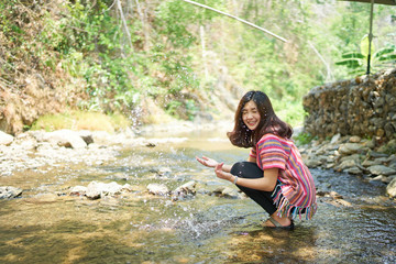Young happy woman playing with stream water