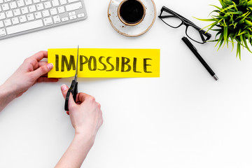 Make the impossible possible. Cutting the part im of written word impossible by sciccors. Office...