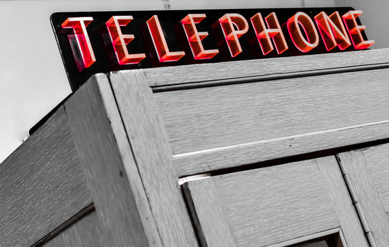 Vintage telephone booth with red neon sign