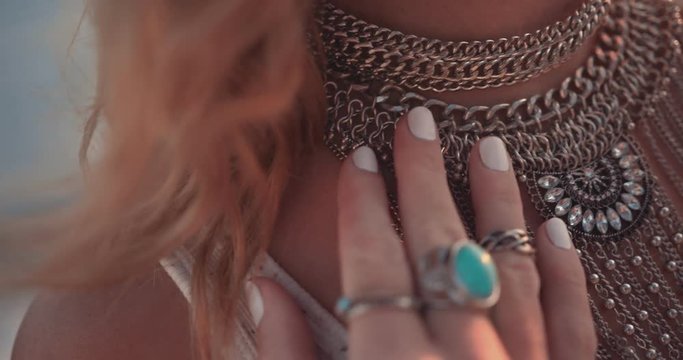 Close-up of boho woman wearing silver rings and necklace outdoors
