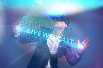 Business, Technology, Internet and network concept. Young businessman working in virtual reality glasses sees the inscription: Live webcast